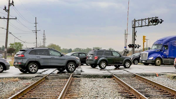 When traffic is slow and heavy and you must cross railroad tracks before reaching the upcoming intersection, you should:
