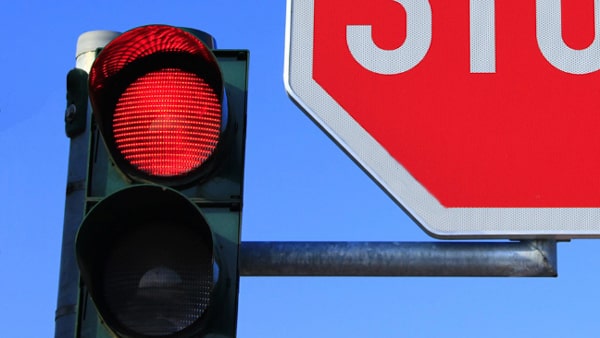 If you are approaching an intersection with a red flashing light, what should you do?