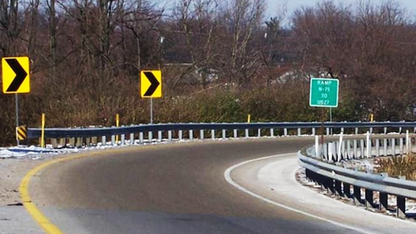 If you exit a freeway with a ramp that curves downhill, you should: