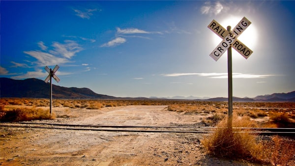 What vehicles must stop at all railroad crossings?
