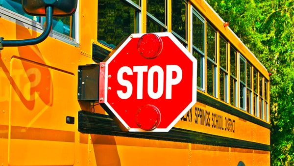 The only time you do not have to stop for a school bus whose red lights are flashing and Stop arm is extended is when you: