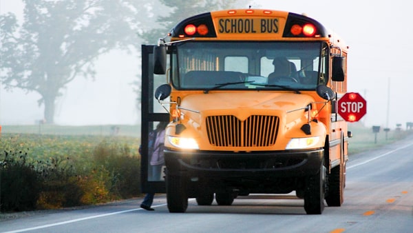 If a school bus stops to unload children on a two-lane highway, vehicles traveling in the opposite direction are: