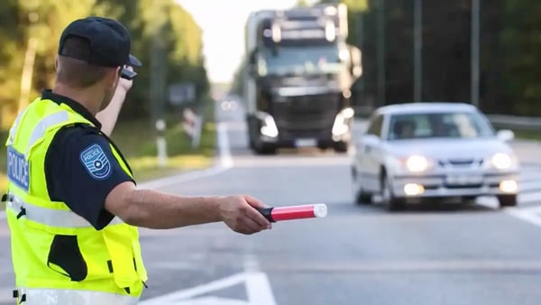 A traffic light is red, but a police officer is telling you to go ahead anyway. What should you do?