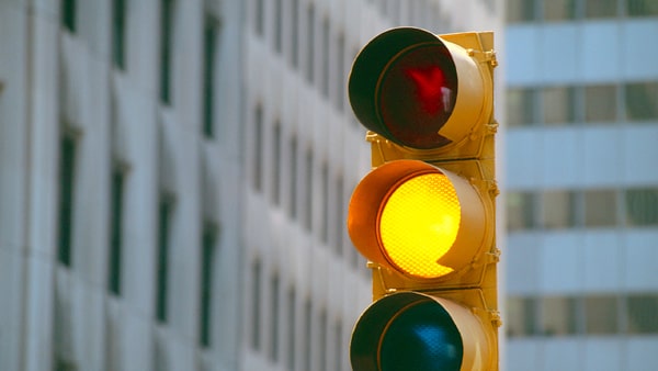 As you near an intersection, the traffic light changes from green to yellow. Your best action would be to: